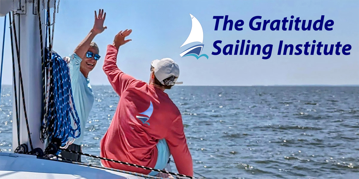 Two sailors sharing a high five while sailing